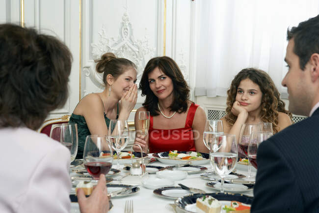 Duas mulheres na mesa de jantar sussurrando — Fotografia de Stock