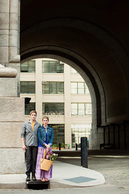 Молода пара стоїть на міському тротуарі — стокове фото