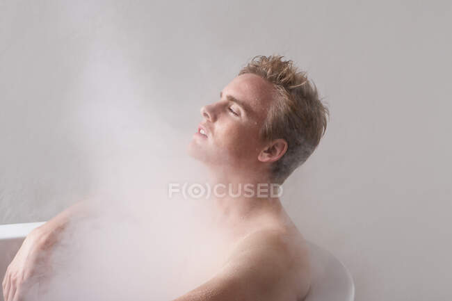 Man in bath with steam — Stock Photo
