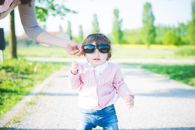 Portrait of female toddler wearing sunglasses in park — Stock Photo