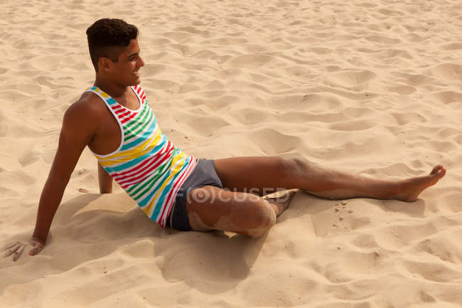Молодий чоловік розслабляється на пляжі — стокове фото