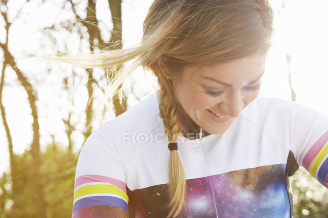 Female cyclist looking down in park — Stock Photo