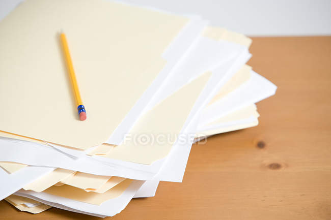 Apilar archivos de papel y lápiz en la mesa - foto de stock