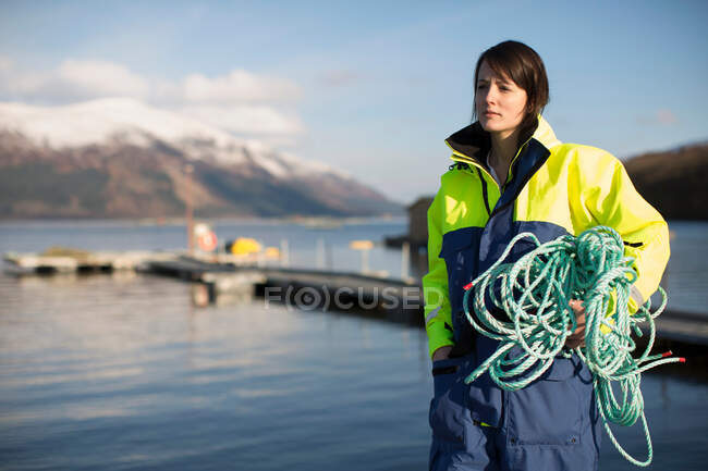 Trabajador en granja de salmón en lago rural - foto de stock