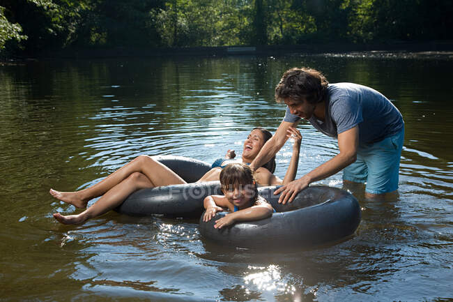Casal e filha se divertindo no lago — Fotografia de Stock