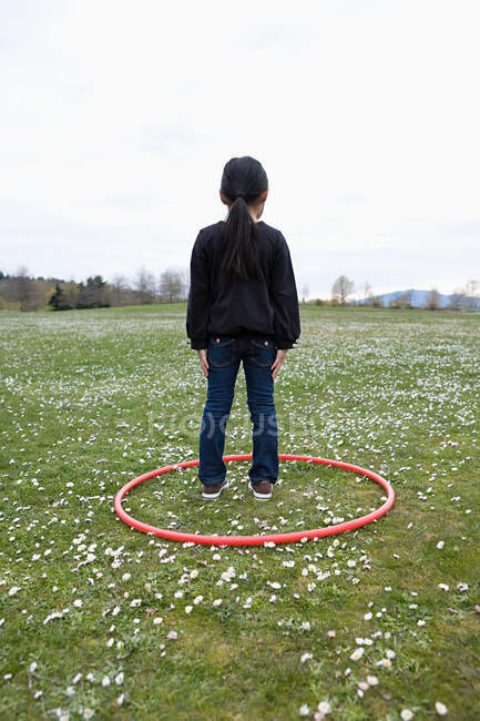 Девушка, стоящая в кольце в поле — стоковое фото