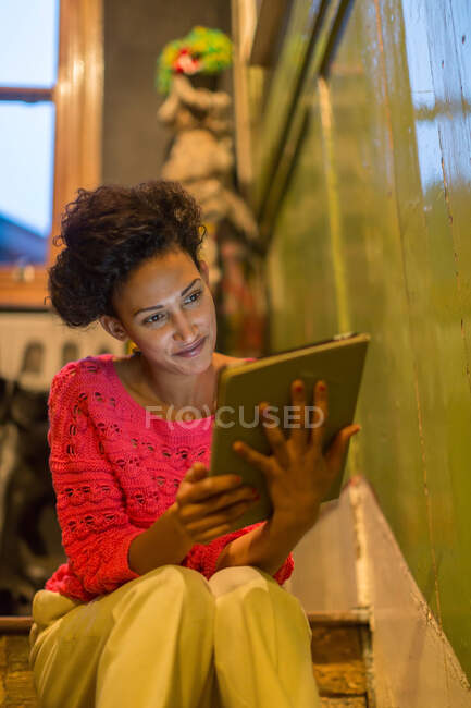 Mujer que usa tableta en los pasos - foto de stock