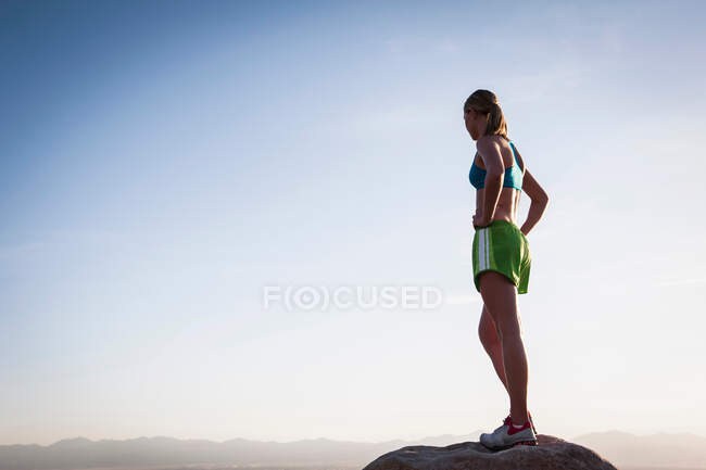 Mujer en roca con vistas al paisaje - foto de stock