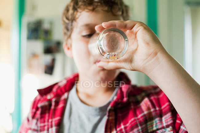 Boy finishing glass of juice — Stock Photo