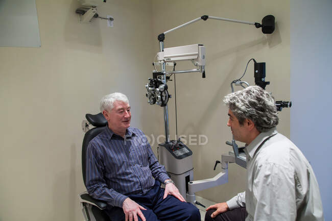 Doctor hablando con el paciente en el consultorio - foto de stock