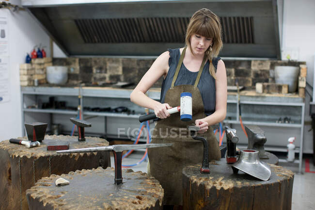Woman metalworking using hammer — Stock Photo