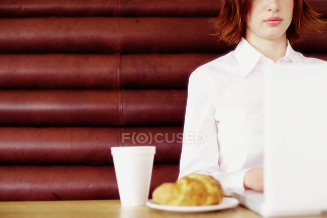 Mulher tomando café da manhã e trabalhando — Fotografia de Stock