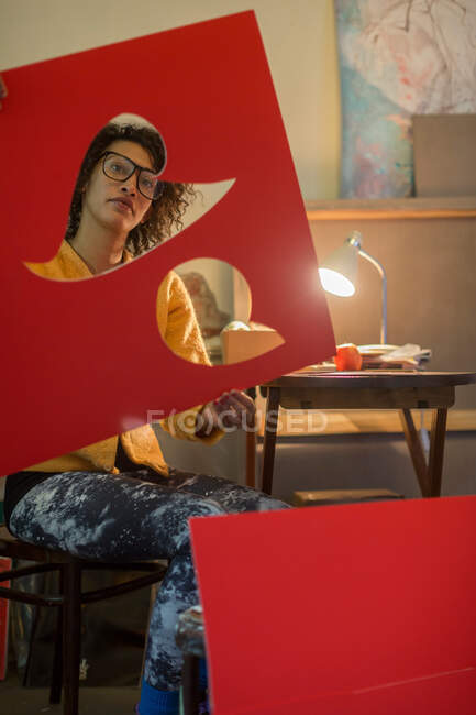 Artist cutting out red cardboard — Stock Photo