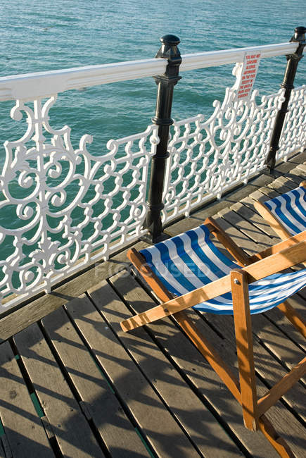 Balcón con tumbonas a la luz del sol por mar - foto de stock