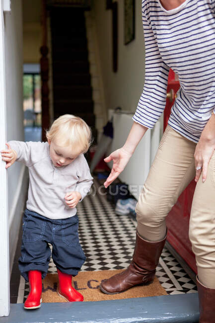 Junge und Mutter treten Haustür ein — Stockfoto