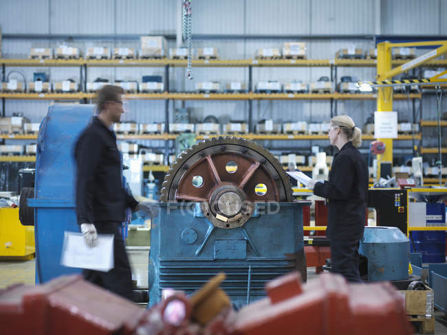 Engineers repairing industrial gearbox in engineering factory — Stock Photo
