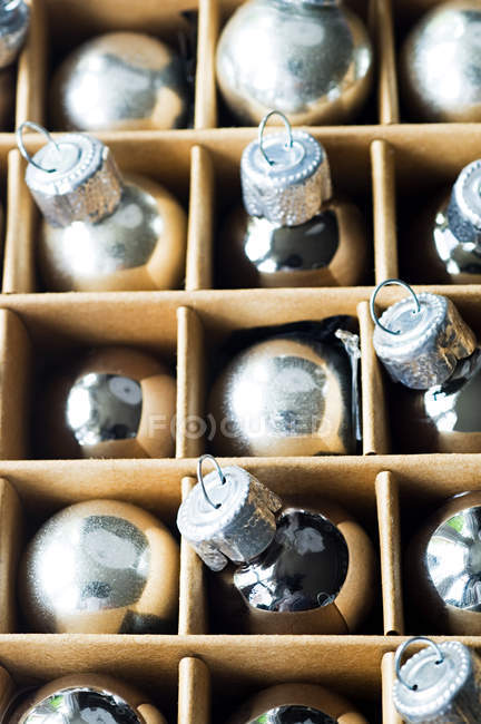 Серебряные рождественские безделушки в картонной коробке — стоковое фото