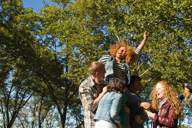 Group of friends cheering in park — Stock Photo