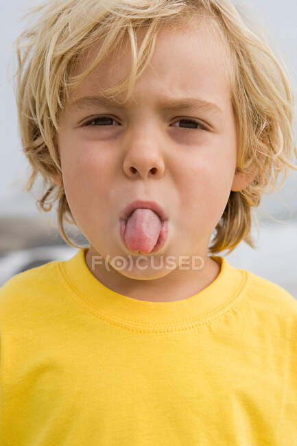 Chico sobresaliendo lengua - foto de stock