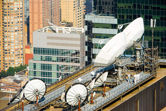 Satellite dishes and buildings — Stock Photo