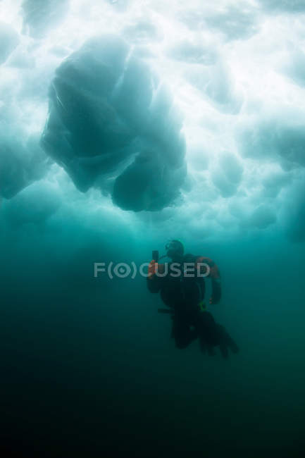 Hombre buceo bajo el glaciar - foto de stock