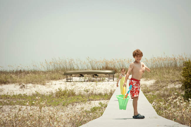 Дети на деревянной дорожке на пляже — стоковое фото