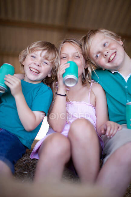 Children drinking soda in garage — Stock Photo