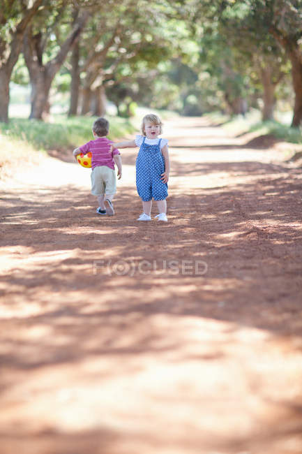Малюки грають на брудній дорозі — стокове фото