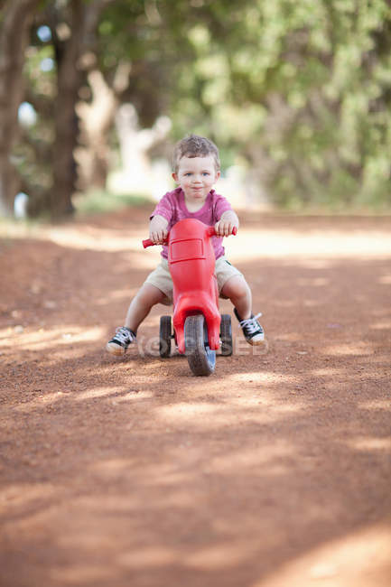 Kleinkind reitet Spielzeug auf Feldweg — Stockfoto