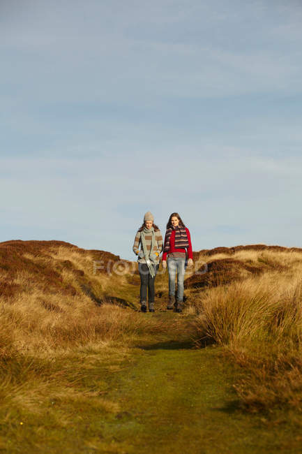 Women walking together on dirt path — Stock Photo