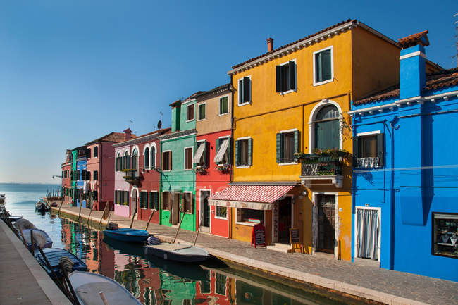 Edifici colorati sopra il canale d'acqua alla luce del sole — Foto stock