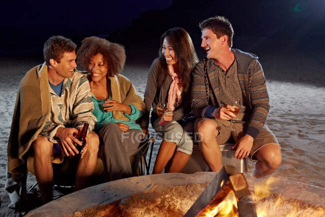 Amigos fazendo festa na praia à noite — Fotografia de Stock