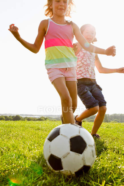 Girls playing soccer in field — Stock Photo