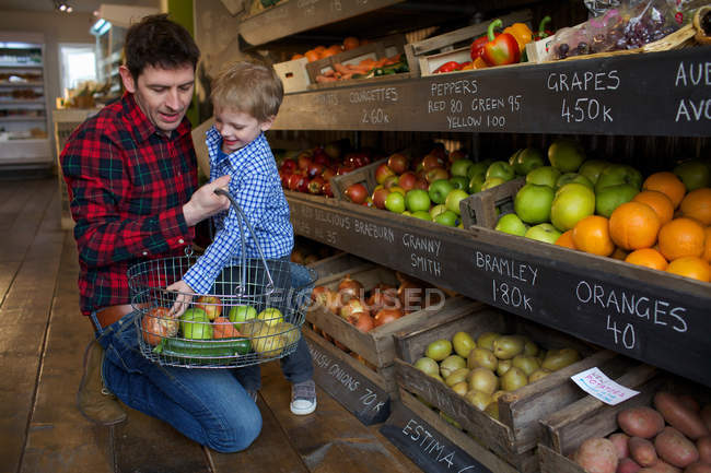 Отец и сын покупают продукты в магазине — стоковое фото