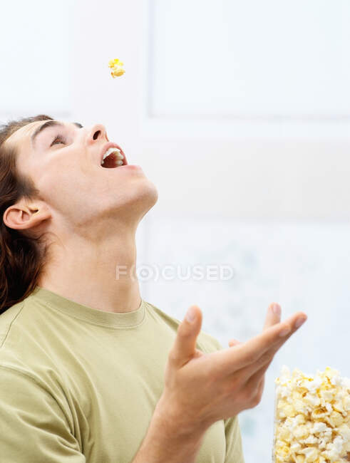 Young man eating popcorn — Stock Photo
