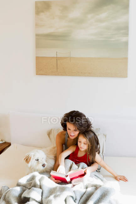 Mutter und Tochter lesen im Bett — Stockfoto