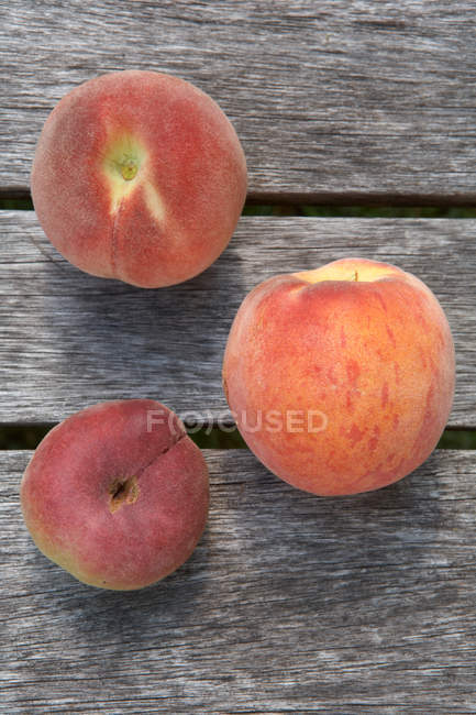 Blick von oben auf frische Pfirsiche auf Holztisch — Stockfoto