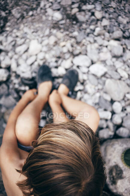 Veduta aerea del ragazzo sul paesaggio roccioso mettere le scarpe, Bludenz, Vorarlberg, Austria — Foto stock
