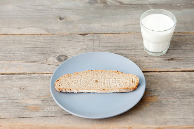 Fetta di pane con bicchiere di latte — Foto stock