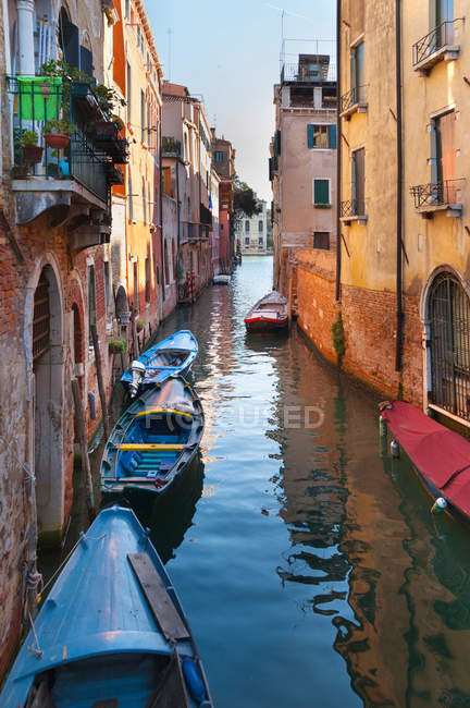 Buildings and rowboats on urban canal — Stock Photo