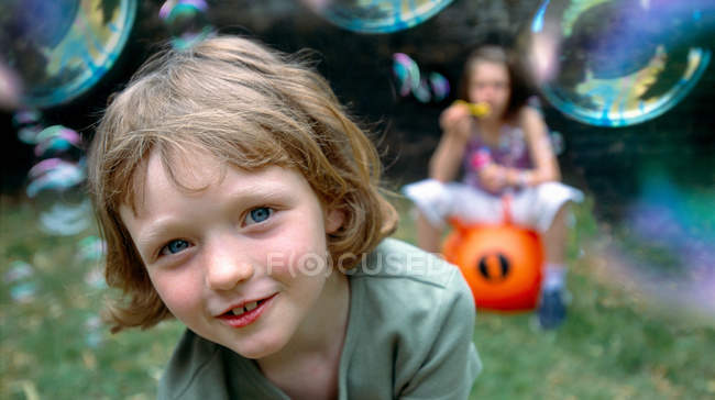 Bambini che giocano con le bolle all'aperto, attenzione selettiva — Foto stock