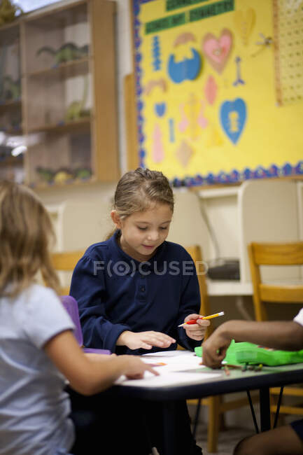 Enfants écrivant en classe — Photo de stock