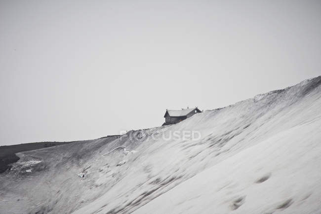 Дом, построенный на снежной вершине холма — стоковое фото
