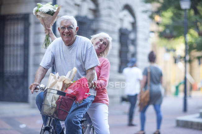 Cape Town, South Africa, elderly couple on a bicycle in city — Stock Photo