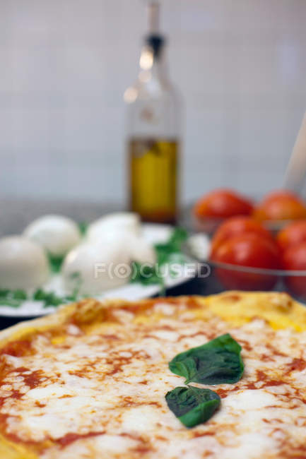 Pizza con hojas de albahaca y verduras - foto de stock
