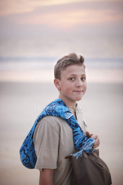 Adolescente niño llevando bufanda y bolso - foto de stock