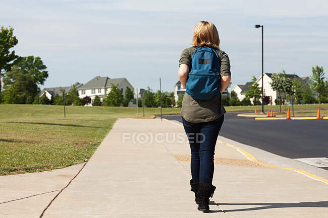 Школьница, идущая по тротуару — стоковое фото