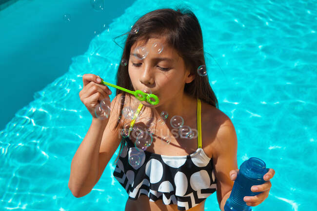 Menina usando top de biquíni com varinha de bolha — Fotografia de Stock