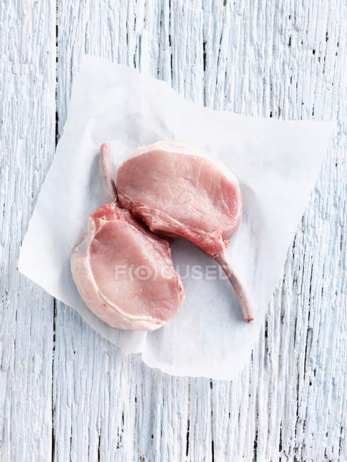 Chuleta de cerdo cruda en papel de carnicero - foto de stock