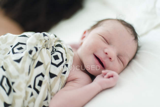Sleeping baby boy smiling — Stock Photo